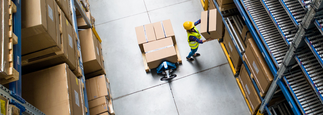 Image of a worker moving boxes in a warehouse