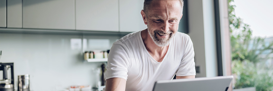 Man reading iPad and smiling